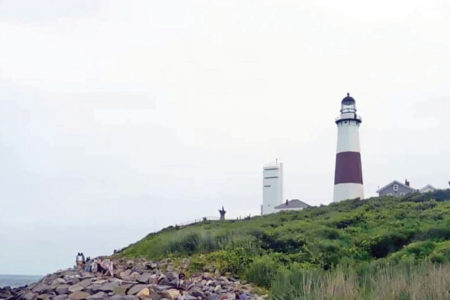 View of a lighthouse on the edge of an island near the rocks