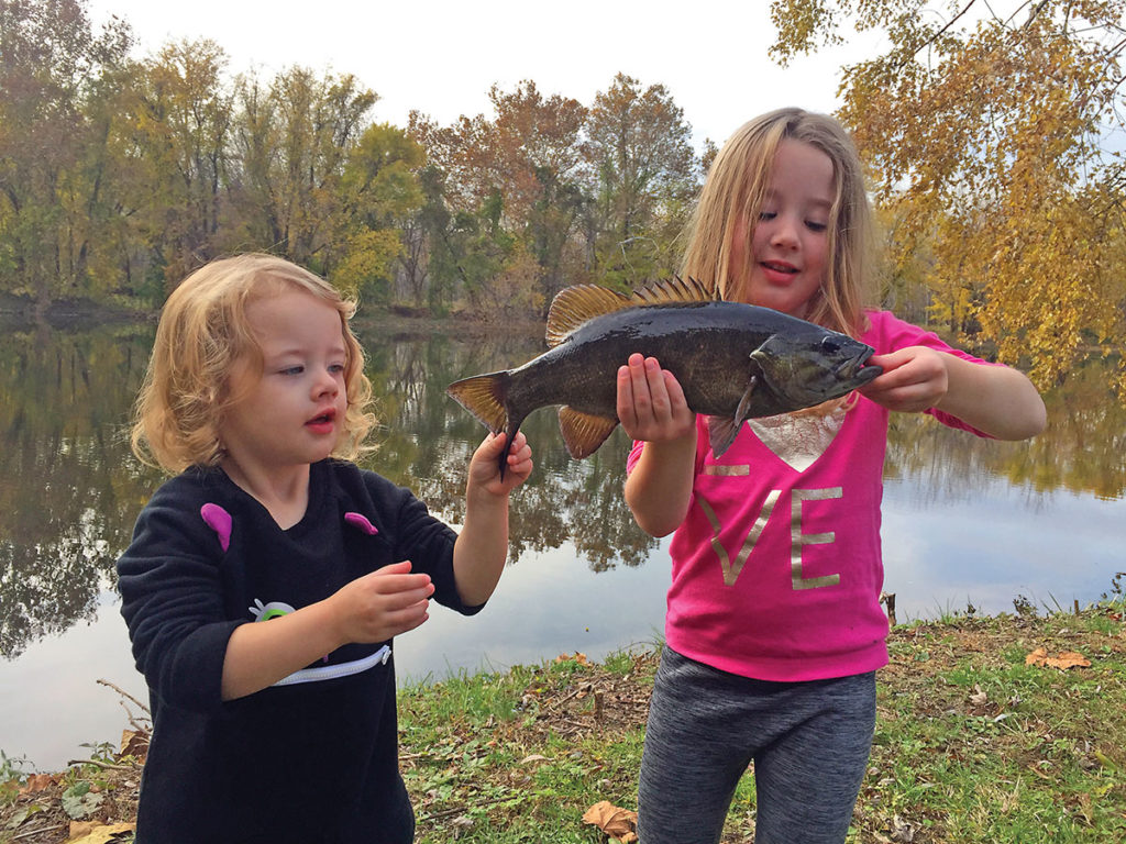 Two girls showing off a black fish