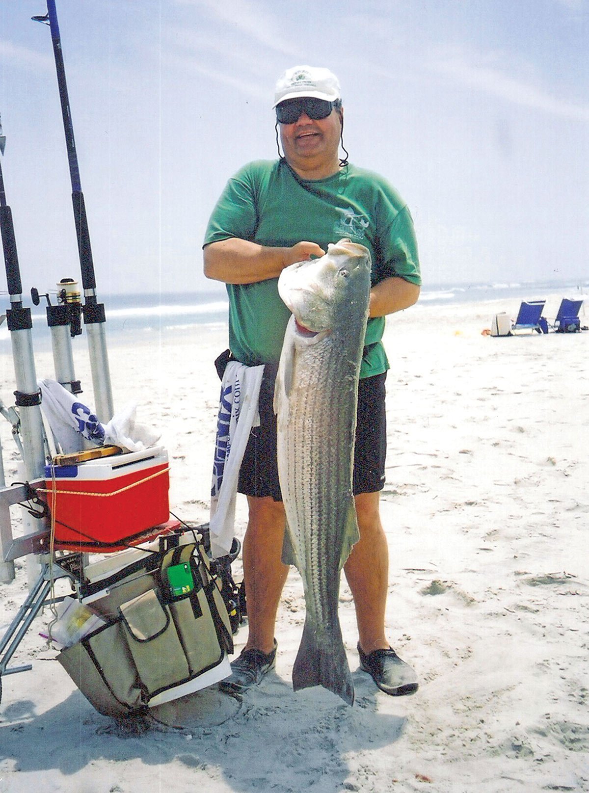 Man on the shore showing the big fish he caught