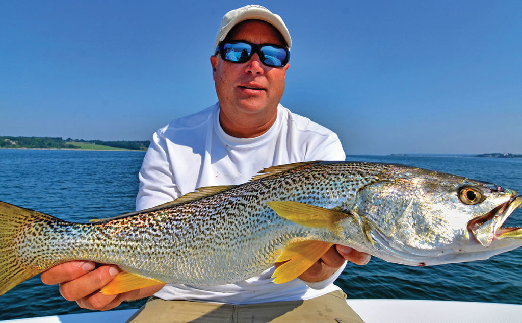 man in cap and sunglasses showing off his huge fish catch