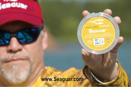 man holding seaguar gold label to camera