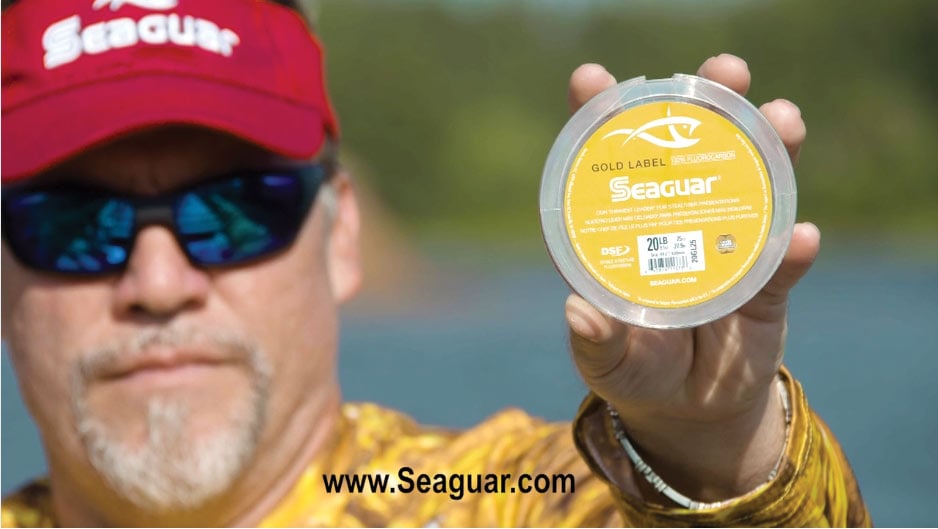 man holding seaguar gold label to camera