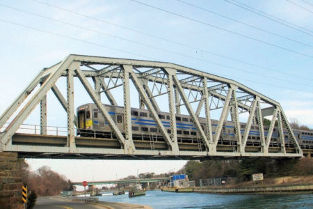 Train passes on a bridge over a canal