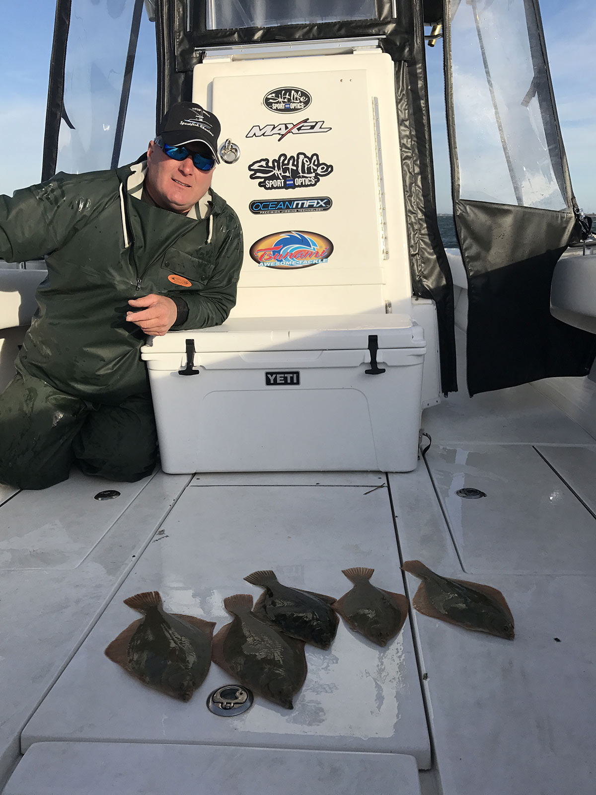 Capt. Scott in a boat showing off the flounder fishes he caught