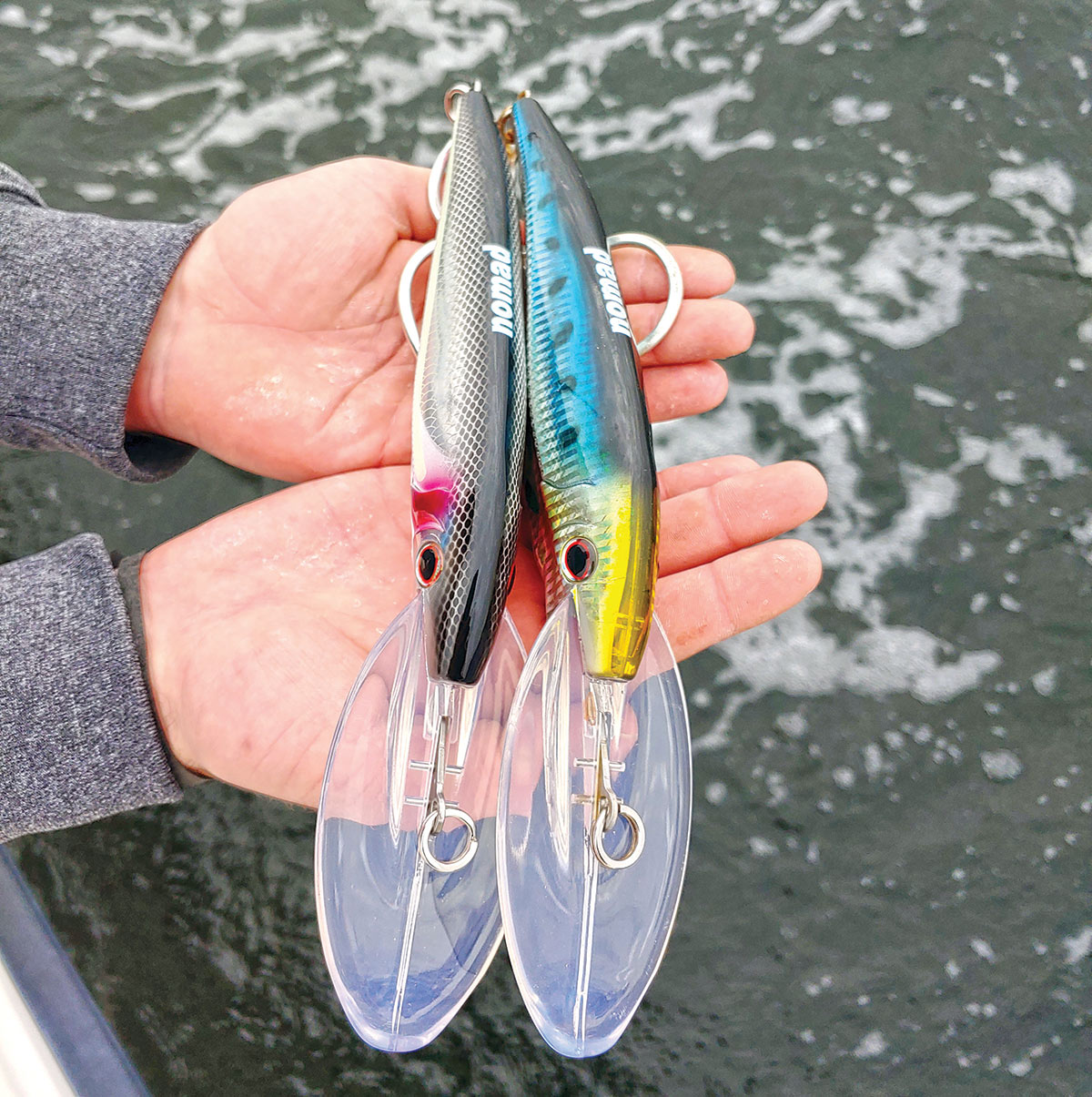Two hands holding up a nomad design tackle DTX deep diving minnow