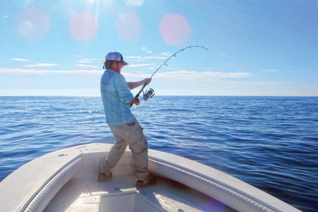 Man on a boat holding a fishing rod