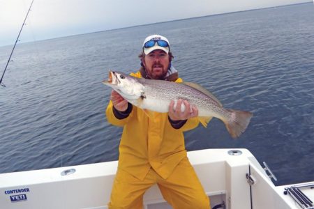 Man on a boat showing a weakfish
