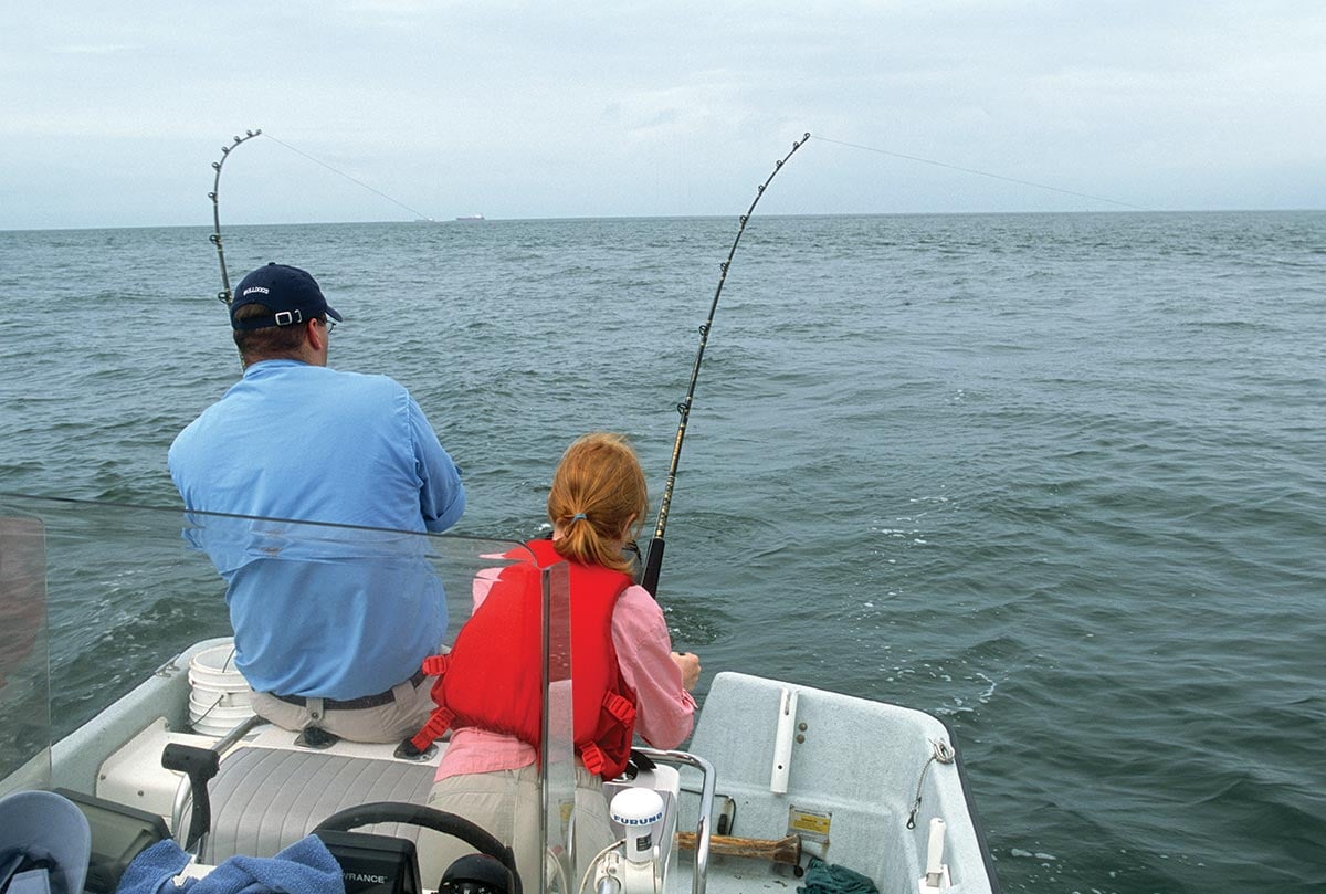 showing their back to the camera while facing the waters fishing