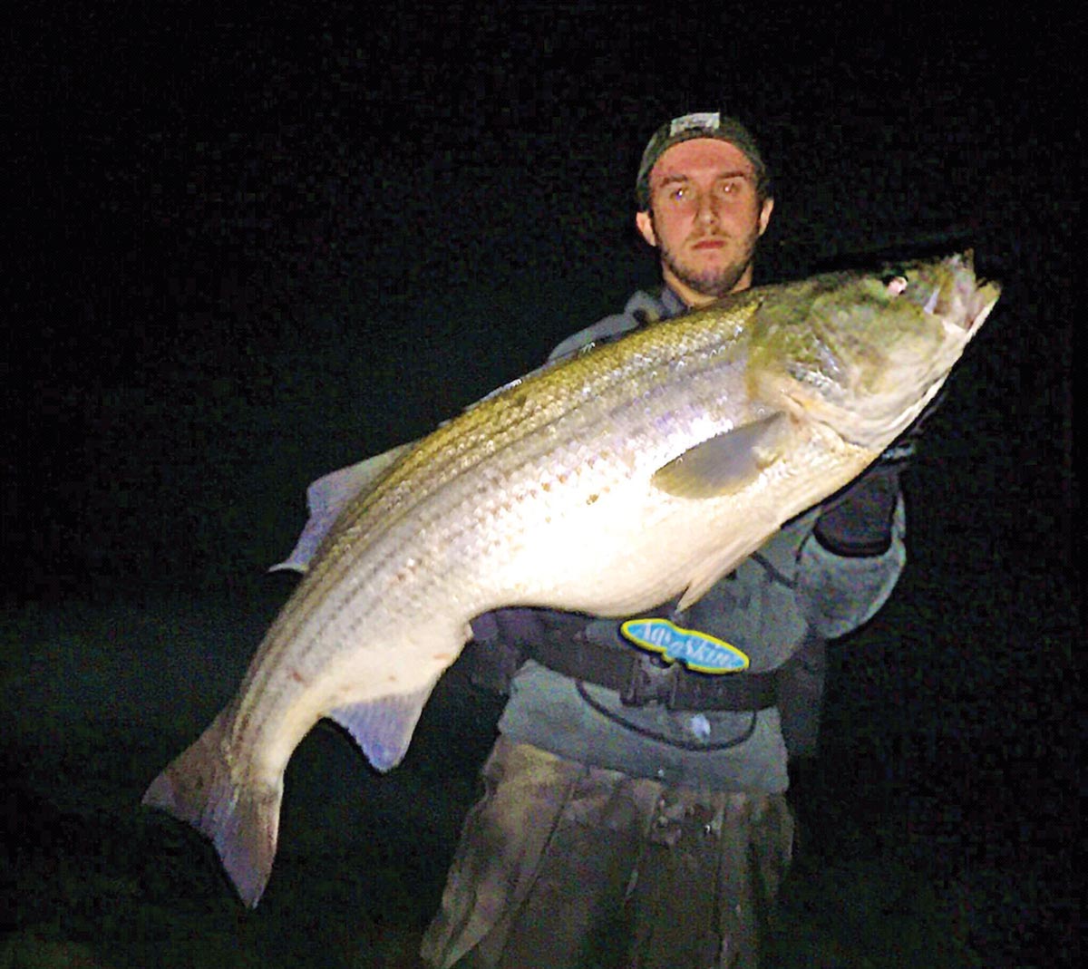 Matt Broderick holding a huge fish caught at night