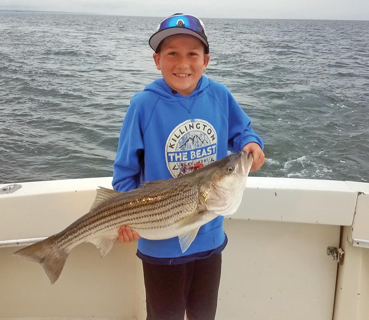 Child holding a striped bass
