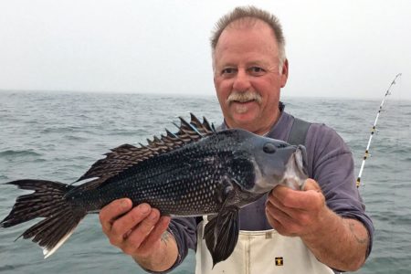 Man holding up his sea bass