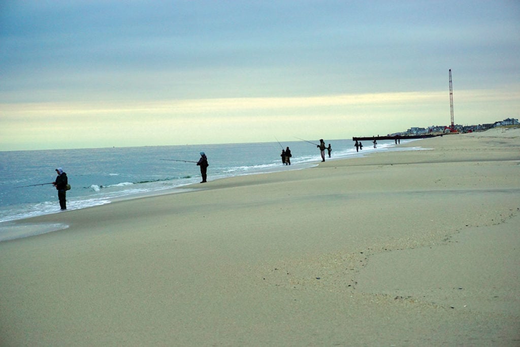A picket fence of surfcasters on the beach at Point Pleasant during beach replenishment efforts in 2018
